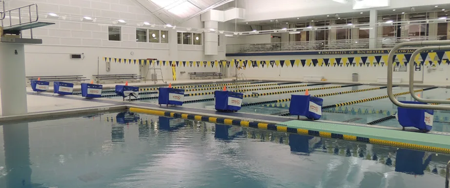 University of Rochester indoor natatorium with lane lines, backstroke flags, and a diving board